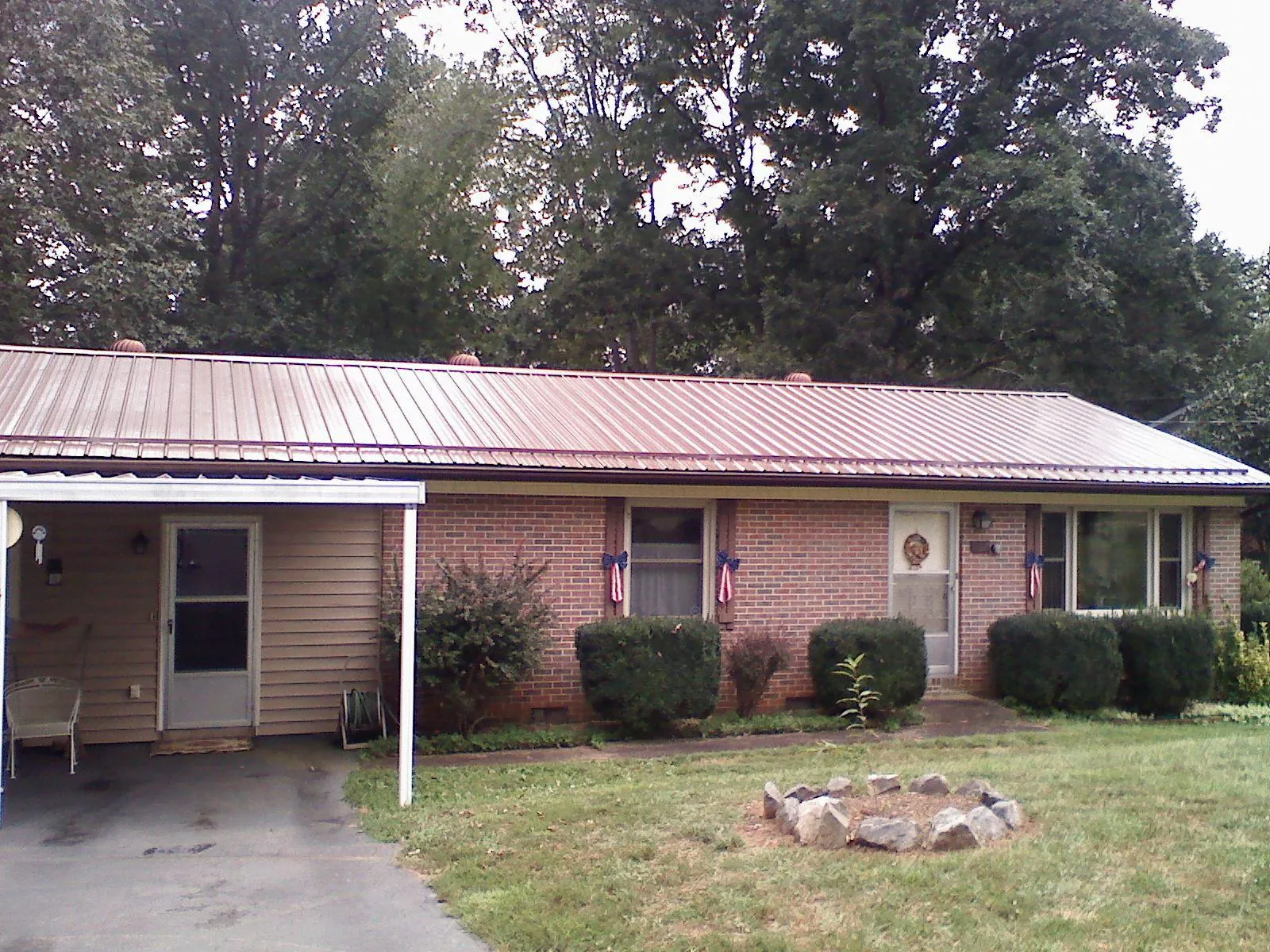 Bronze metal roof and carport on a brick ranch home — Roof Repair work by our crew in Leonard